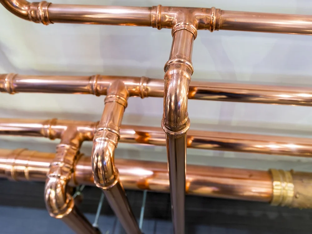 Copper water supply pipes with soldered connections demonstrating excellent corrosion resistance and thermal conductivity for residential and commercial plumbing applications